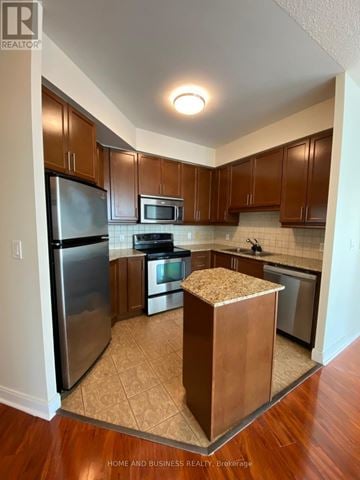 Mississauga (City Centre) condo for rent - A kitchen with wooden cabinets and a refrigerator.