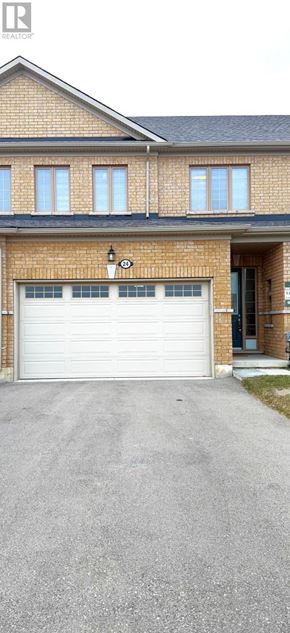 Tillsonburg townhouse for rent - A house with a white garage door and a brick facade.