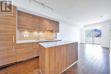 Toronto (Annex) condo for rent - A modern kitchen with wooden cabinets and a white countertop.