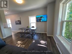 Orillia multi-family for rent - A living room with a flat screen TV mounted on the wall.