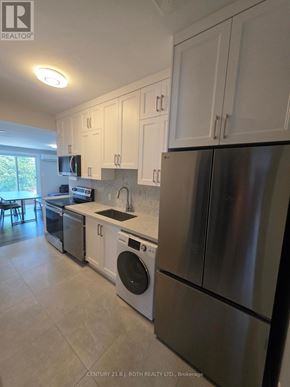 Orillia multi-family for rent - A kitchen with white cabinets and stainless steel appliances.