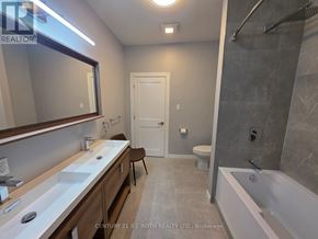 Orillia multi-family for rent - A bathroom with a white tub, sink, and toilet.