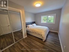 Orillia multi-family for rent - A bedroom with a bed, a window, and a sliding door.