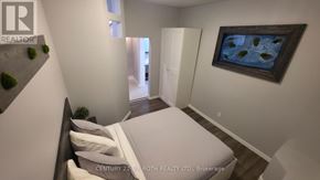 Orillia multi-family for rent - A bedroom with a bed, a painting, and a plant.