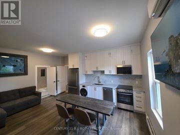 Orillia multi-family for rent - A modern kitchen with a dining table and chairs.
