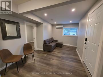 Orillia multi-family for rent - A living room with a brown chair and a grey couch.