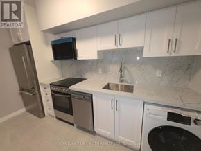 Orillia multi-family for rent - A kitchen with white cabinets and a marble countertop.