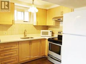 Toronto (Pleasant View) apartment for rent - A kitchen with wooden cabinets and a white refrigerator.