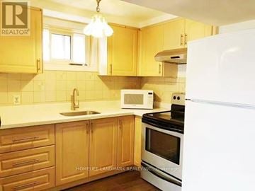 Toronto (Pleasant View) apartment for rent - A kitchen with wooden cabinets and a white refrigerator.
