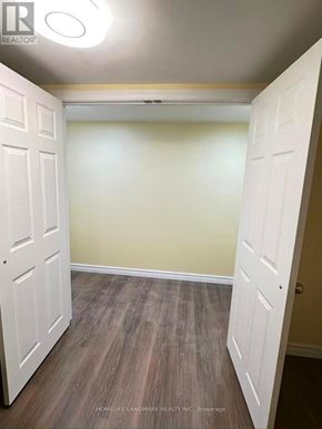 Toronto (Pleasant View) apartment for rent - A room with a white door and wooden flooring.