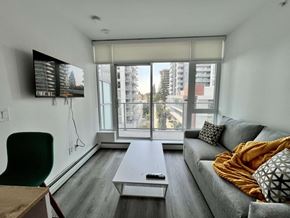 Surrey apartment for rent - A living room with a grey couch and a white coffee table.