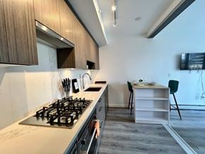 Surrey apartment for rent - A kitchen with a stove and a dining table.