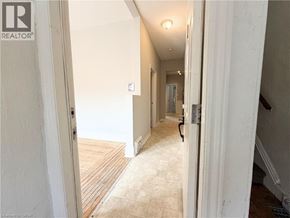 Hamilton apartment for rent - A hallway with a wooden floor and white walls.