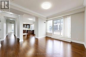 Toronto (York University Heights) condo for rent - A spacious room with wooden floors and white walls.