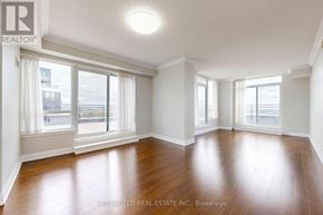 Toronto (York University Heights) condo for rent - A spacious room with wooden floors and large windows.