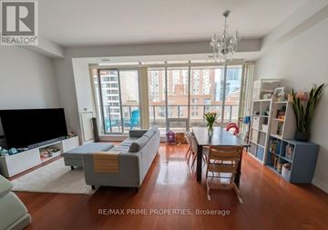 Toronto (Bay Street Corridor) condo for rent - A living room with a grey couch, a television, a dining table with chairs, and a chandelier.