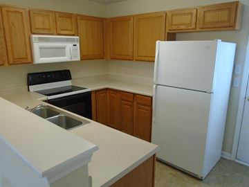 Lebanon apartment for rent - a kitchen with white appliances and wooden cabinets