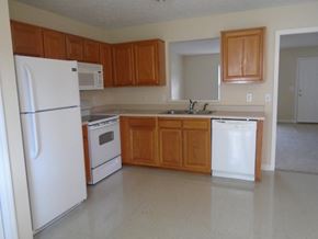 Lebanon apartment for rent - an empty kitchen with white appliances and wooden cabinets
