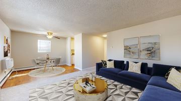 Arvada apartment for rent - A living room with a blue couch and a coffee table.