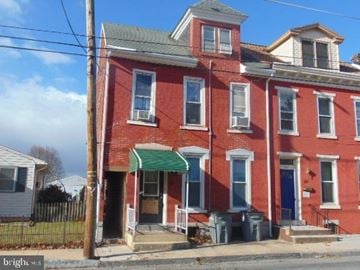 Lebanon apartment for rent - A red brick house with a green awning.