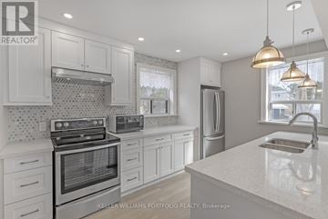 Toronto (O'connor-Parkview) apartment for rent - A modern kitchen with white cabinets and stainless steel appliances.