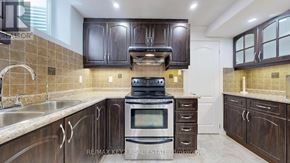 Markham (Cachet) apartment for rent - A kitchen with dark brown cabinets and a stove top oven.