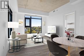 Ottawa apartment for rent - A modern living room with a large window and a view of trees outside.