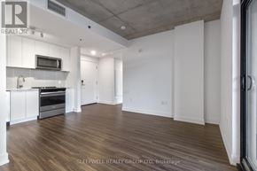 Ottawa apartment for rent - A spacious room with wooden flooring and white walls.