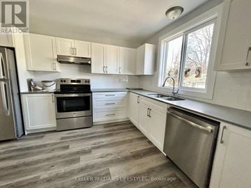 London South (South I) triplex for rent - A kitchen with white cabinets and a stainless steel dishwasher.