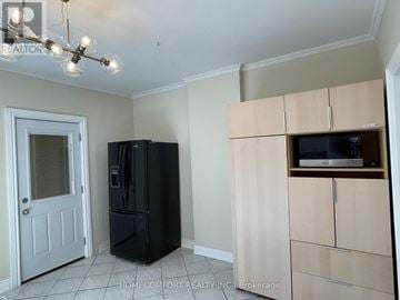 Toronto (Weston-Pellam Park) apartment for rent - A black refrigerator sits in a kitchen with a white door and a cabinet with a microwave.