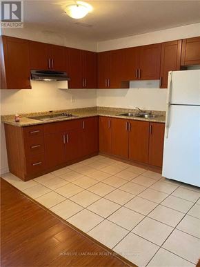 Toronto (Pleasant View) apartment for rent - A kitchen with brown cabinets and a white refrigerator.