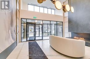 Oakville (Go Glenorchy) condo for rent - A modern office lobby with a fireplace and a reception desk.