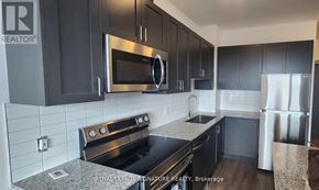 Oakville (Go Glenorchy) condo for rent - A kitchen with black cabinets and stainless steel appliances.
