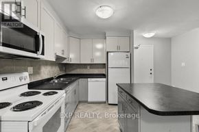 St. Catharines (Bunting/Linwell) multi-family for rent - A kitchen with white appliances and black countertops.