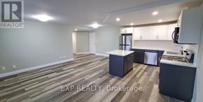 St. Catharines (Vine/Linwell) multi-family for rent - A realtor's office with wood flooring and a kitchenette.