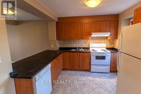 Niagara Falls (Casey) townhouse for rent - A kitchen with wooden cabinets and a white dishwasher.