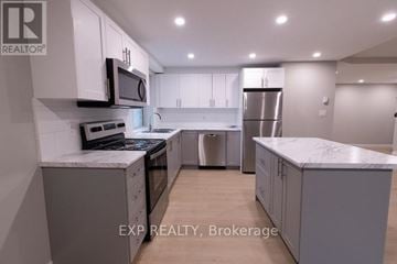 St. Catharines (E. Chester) multi-family for rent - A modern kitchen with white cabinets and stainless steel appliances.