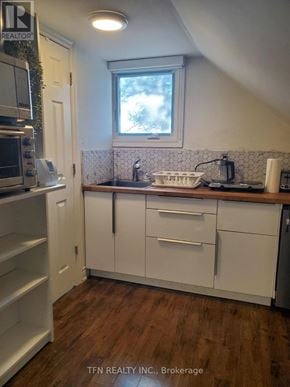 King apartment for rent - A kitchen with white cabinets and a window above the sink.