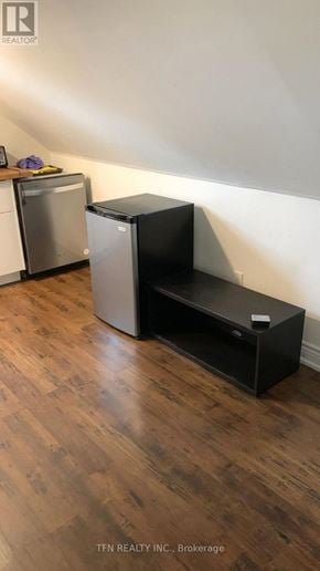 King apartment for rent - A black filing cabinet sits in a room with a wooden floor.