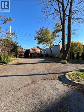 Dundas apartment for rent - A street view with houses and trees on a sunny day.