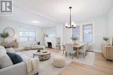 Toronto (Annex) duplex for rent - A well-lit, spacious living room with a grey sofa, a coffee table, and a dining table set up.