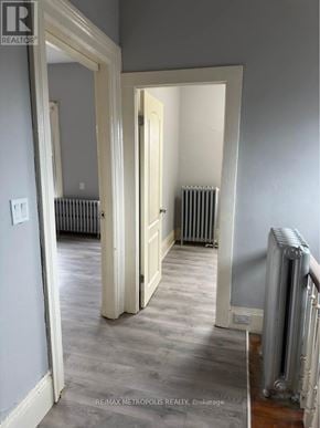 St. Catharines (E. Chester) triplex for rent - A hallway with a white door and a radiator on the wall.