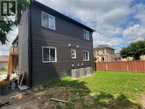 Brantford apartment for rent - A house with a brown wooden exterior and a brown fence.