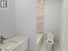 Brantford apartment for rent - A white toilet in a bathroom with a white sink.