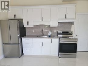 Brantford apartment for rent - A kitchen with white cabinets and a stainless steel refrigerator.