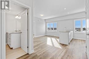 Russell multi-family for rent - A realtor photo of a white kitchen with wood floors and a view of the outdoors through the windows.
