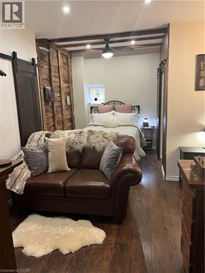 Dundas apartment for rent - A brown leather couch with a white rug in front of it.