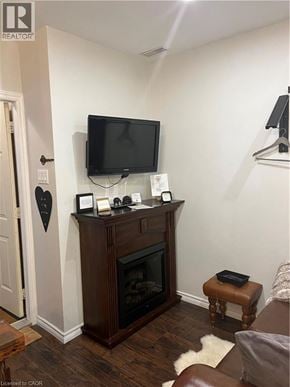 Dundas apartment for rent - A living room with a fireplace and a flat screen TV mounted above it.