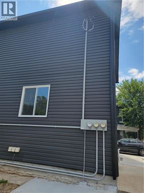 Brantford apartment for rent - A house with a grey siding and a window.