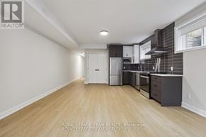 Ottawa apartment for rent - A kitchen with white cabinets and a white refrigerator in a room with wooden floors and white walls.